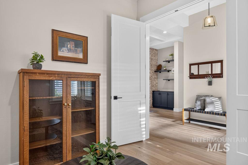 Interior doorway opens to a bright living area with built-in shelves and wood flooring.