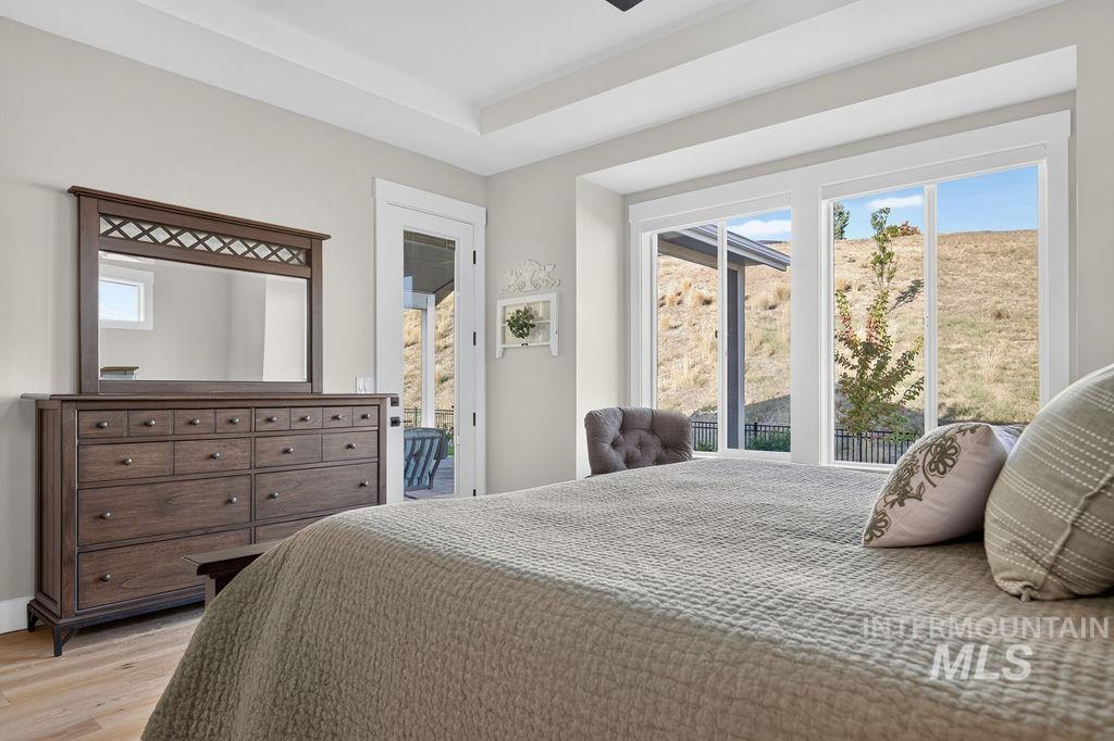 Bedroom with a large bed and wide windows overlooking a dry hillside.