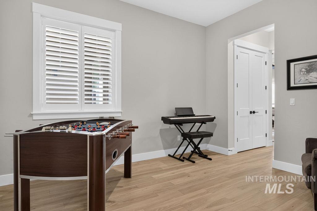 Game room with a foosball table and electronic keyboard beside a shuttered window.