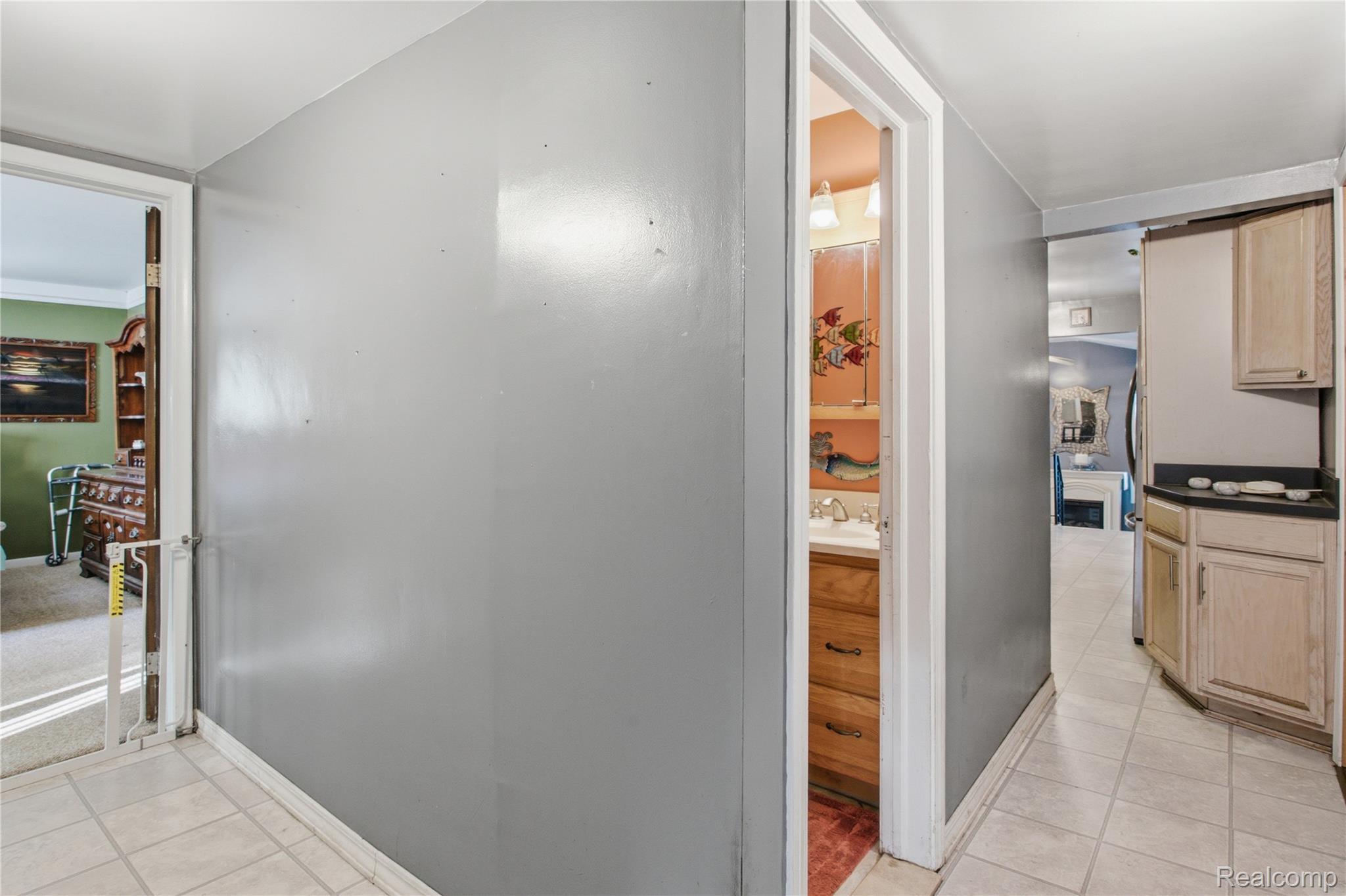 Tiled hallway with light wood cabinetry and views into adjoining rooms.
