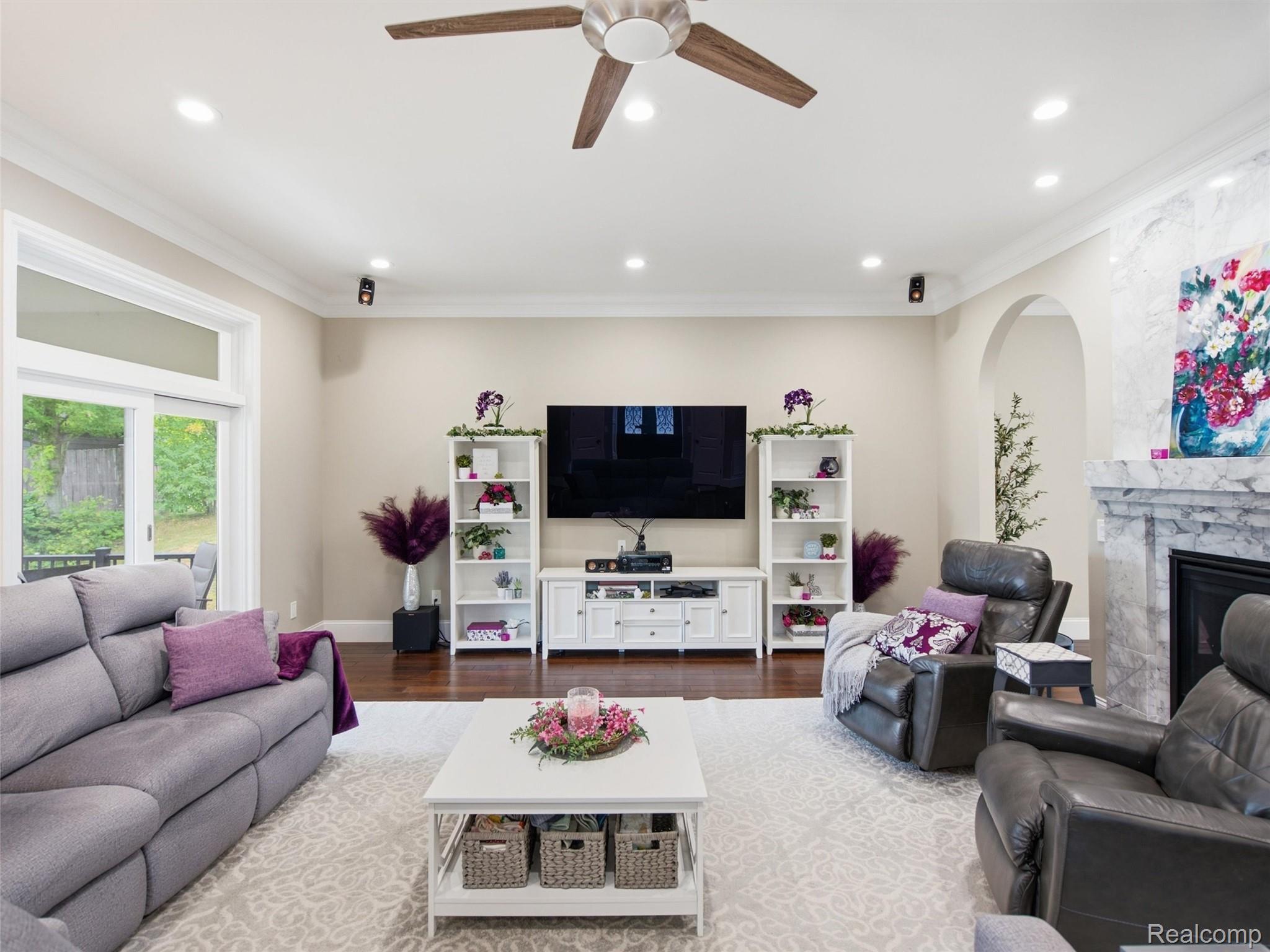Furnished living room with a TV wall, marble fireplace, and sliding glass door.
