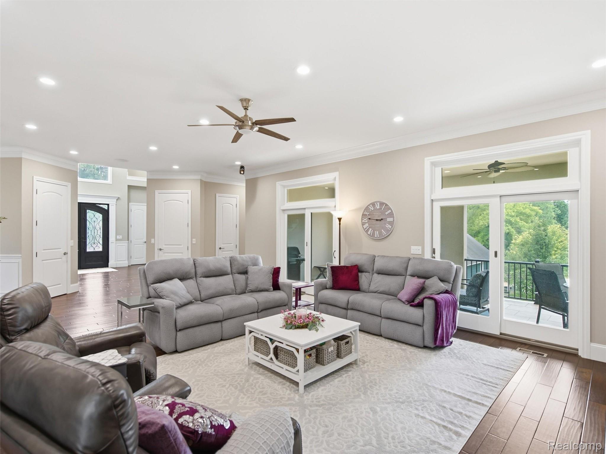 Living room with gray sofas, a white coffee table, and sliding doors to a tree-lined deck.