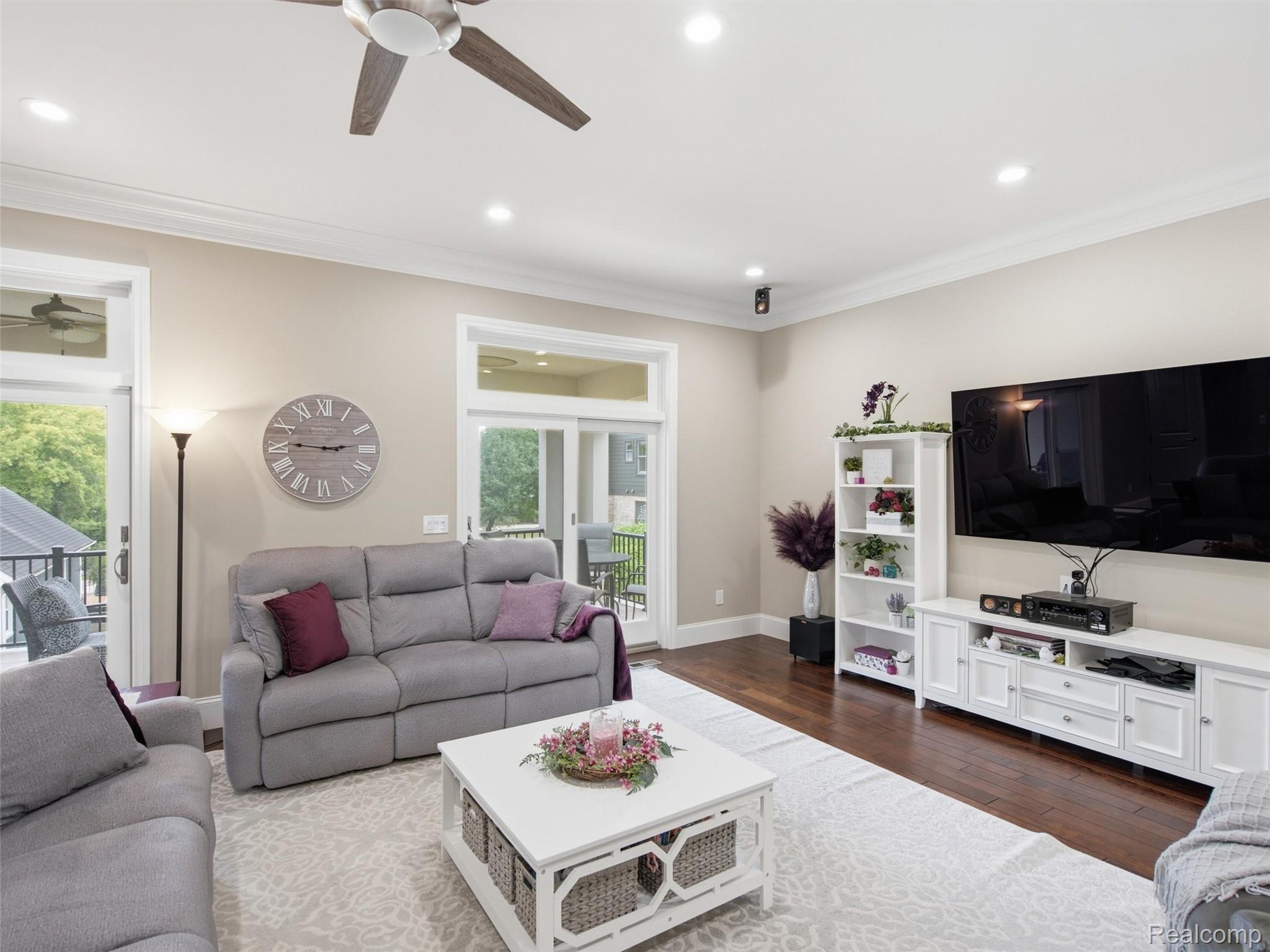 Living room with gray sofas, a wall-mounted television, and sliding doors to a deck.