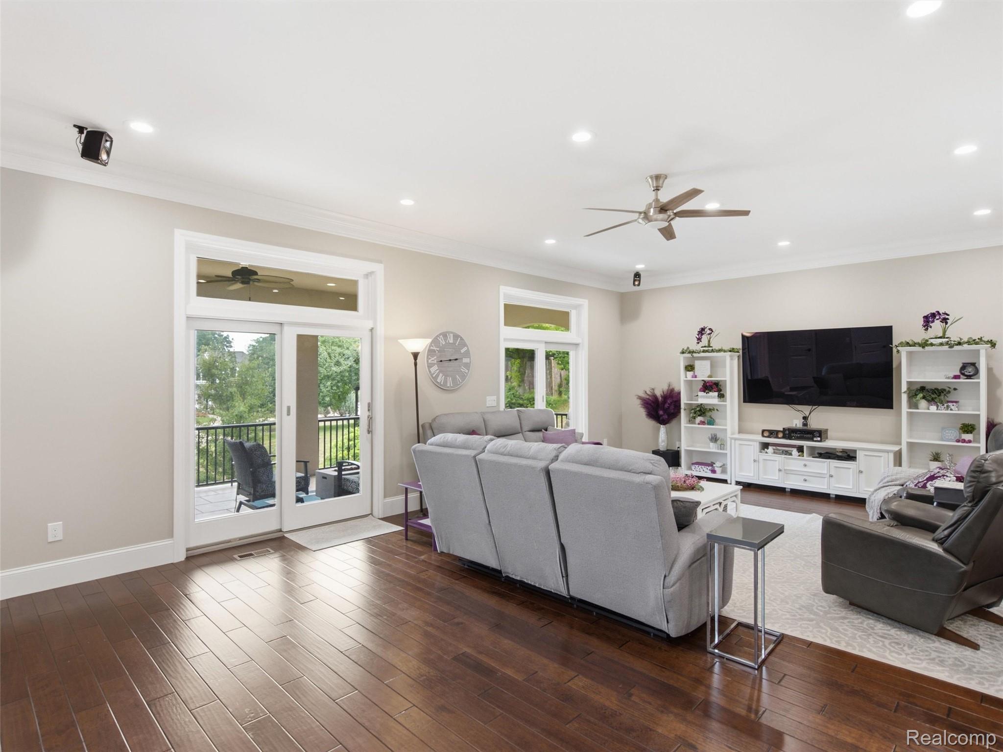 Living room with gray sectional, wall-mounted television, and sliding doors to a balcony.