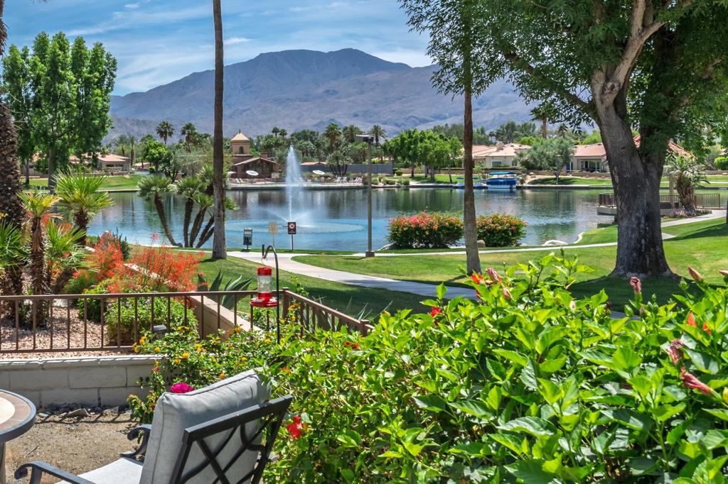 Backyard patio overlooking a lake, with a fountain and mountains in the distance.
