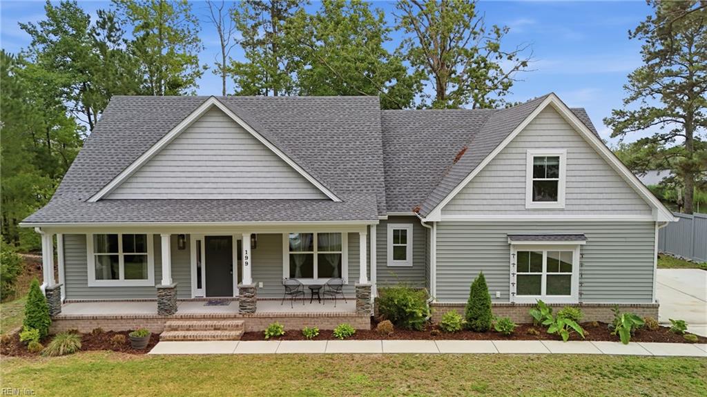 Gray-sided home with multiple gables, a covered front porch, and landscaped yard.