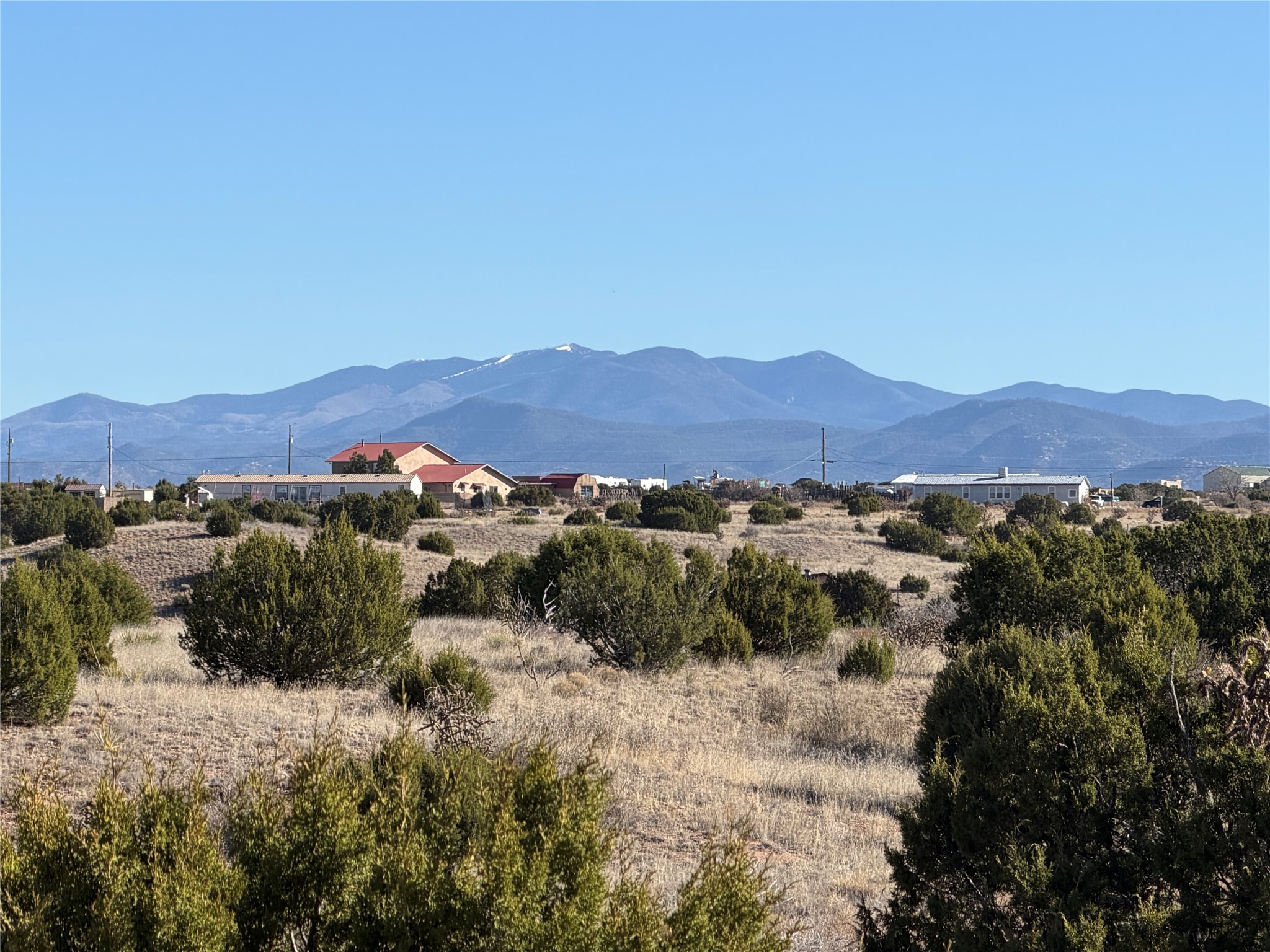 High-desert landscape with scattered homes and a mountain range beyond.