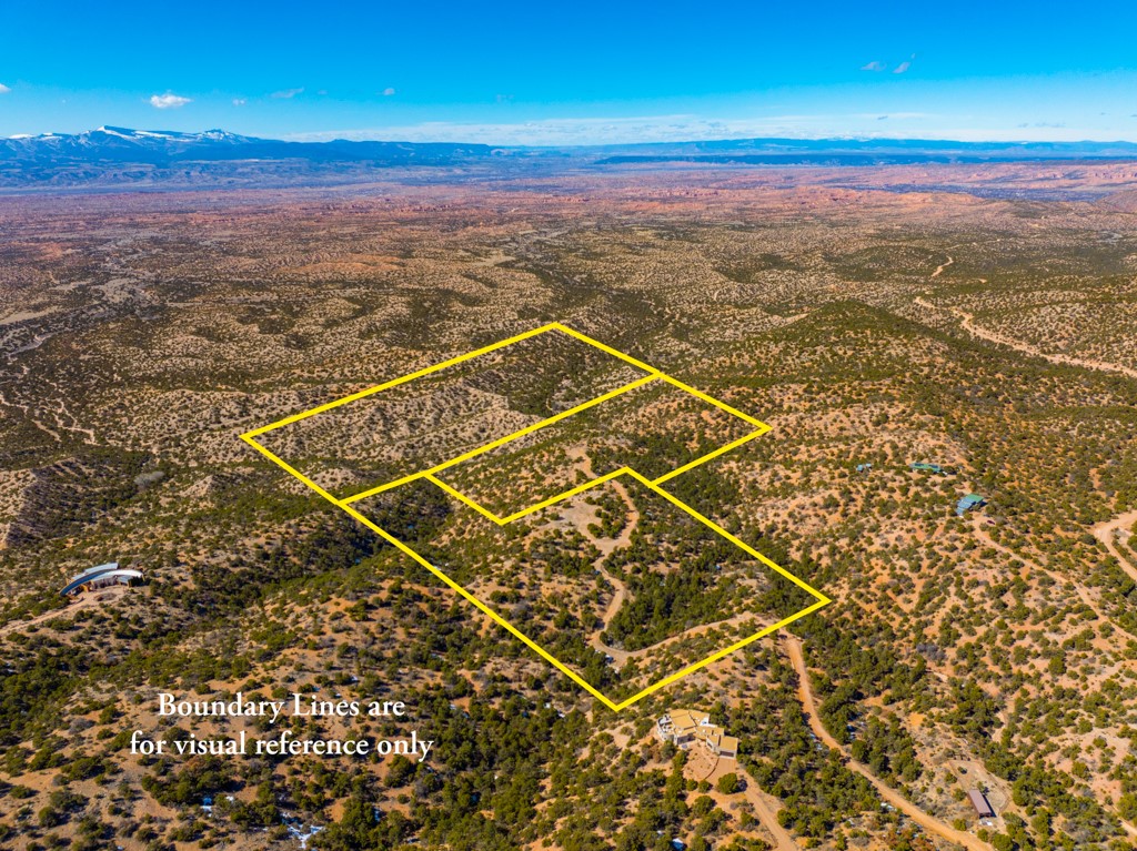 Three rural lots outlined in yellow across scrubland, with dirt roads and mountains in the distance.