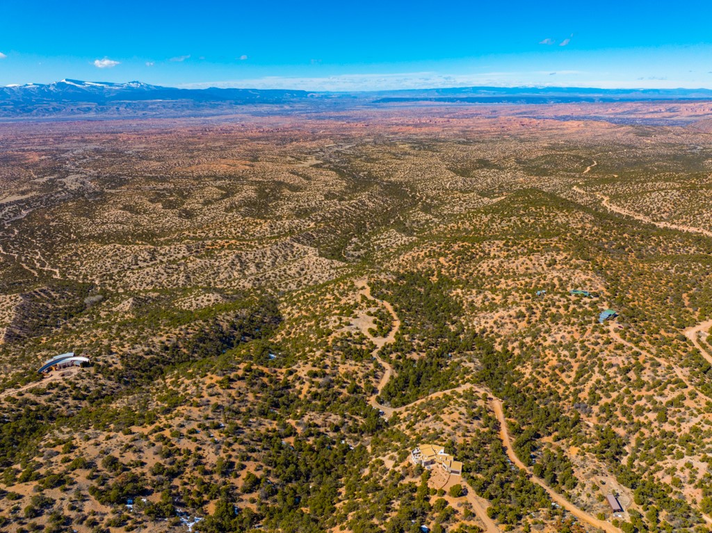 Aerial view of scrub-covered lots with winding dirt roads and distant mountains.