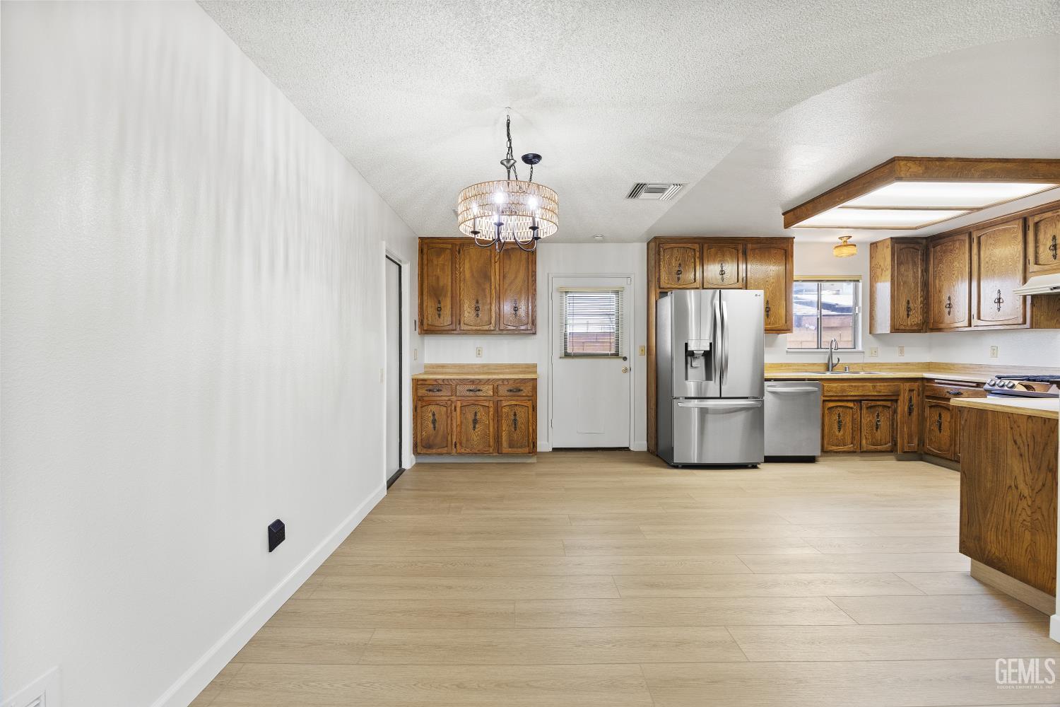 Kitchen with ornate wood cabinets, stainless steel appliances, and a spacious open floor area.