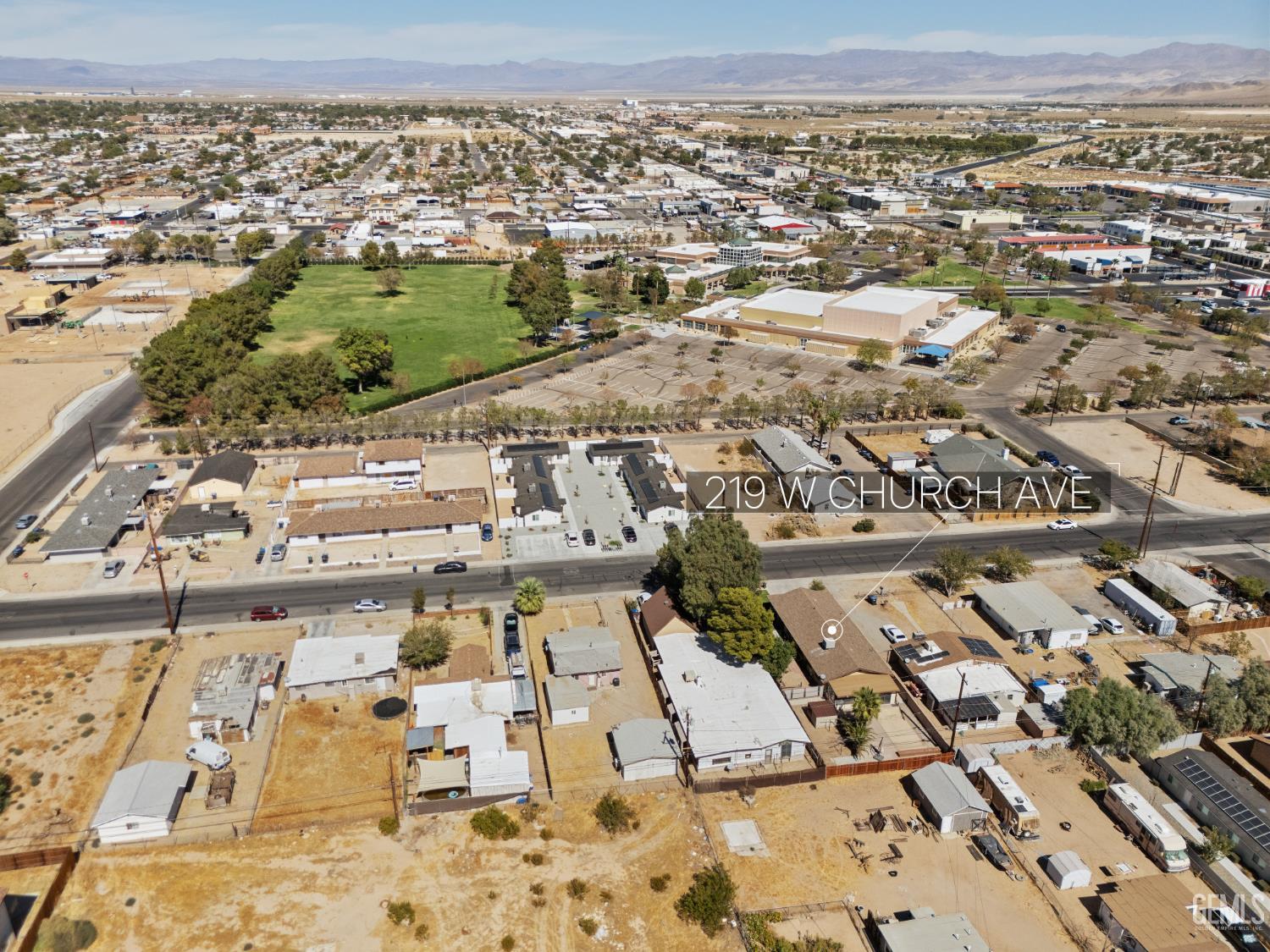 Aerial view of 219 W Church Avenue, marked among nearby homes with a park and mountains beyond.