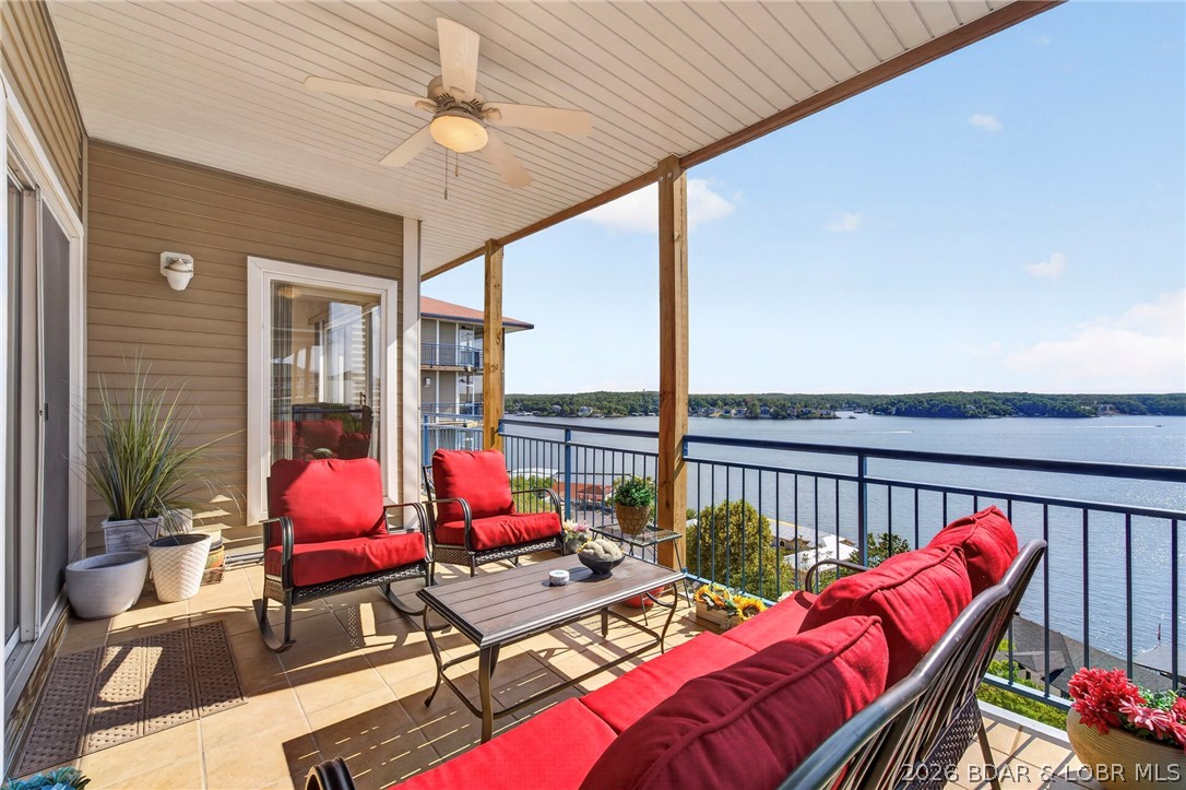 Covered balcony with red seating and an expansive lake view.