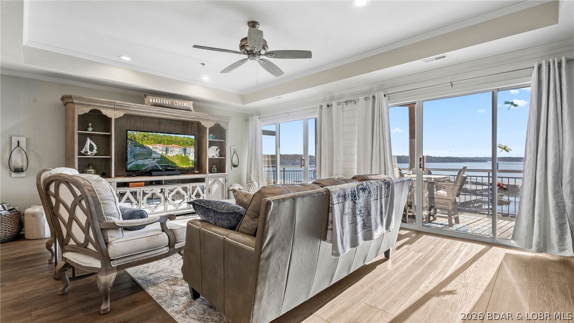 Living room with leather sofa and lake views through sliding glass doors.