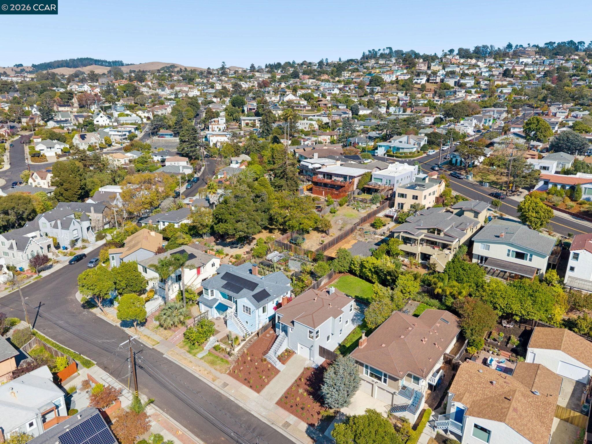 Aerial view of an El Cerrito neighborhood with homes, tree-lined streets, and rolling hills.