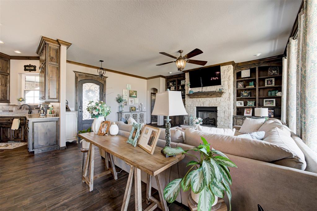 Living room with a stone fireplace, built-in shelves, and dining table behind the sofa.
