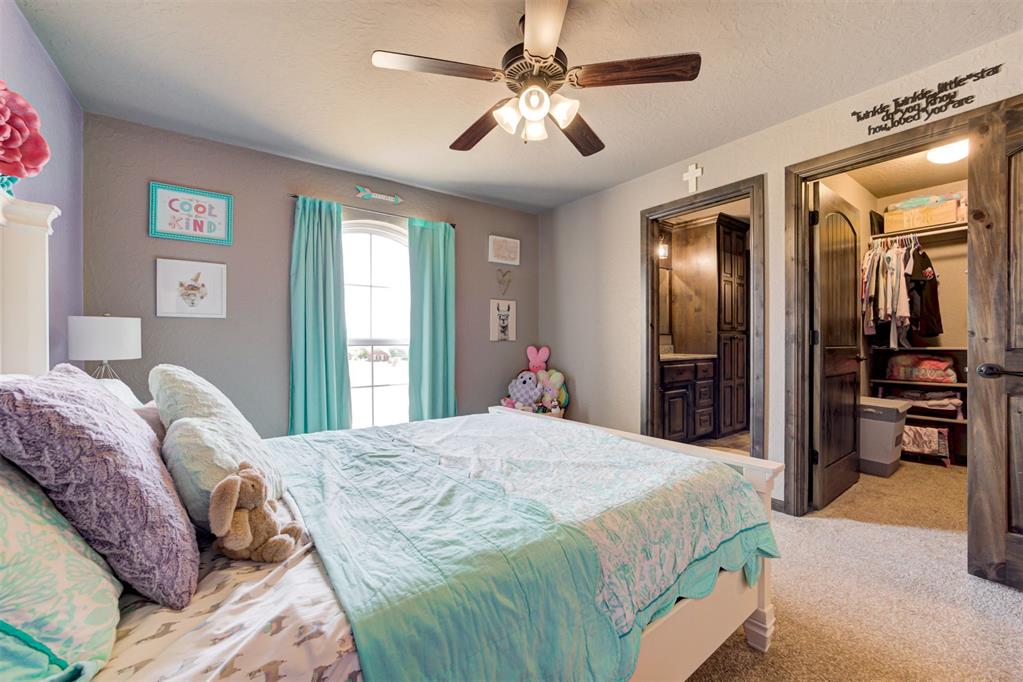 Bedroom with pale aqua bedding, turquoise curtains, plush toys, and dark wood closet doors.