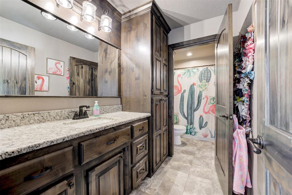 Bathroom with a dark wood vanity and a cactus-and-flamingo shower curtain.
