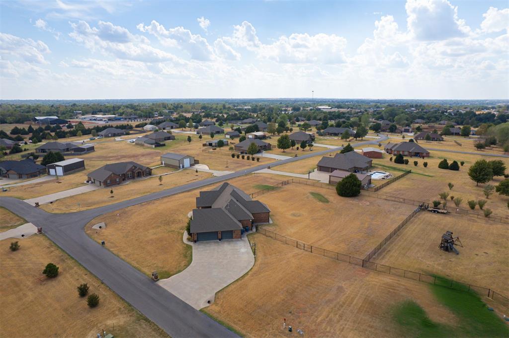 Aerial view of a home on a large lot, with fenced yards and neighborhood streets nearby.