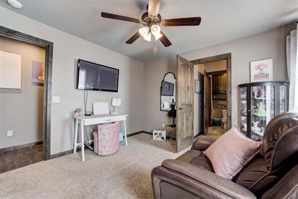 Furnished room with a brown leather sofa, wall-mounted television, and glass-front display cabinet.