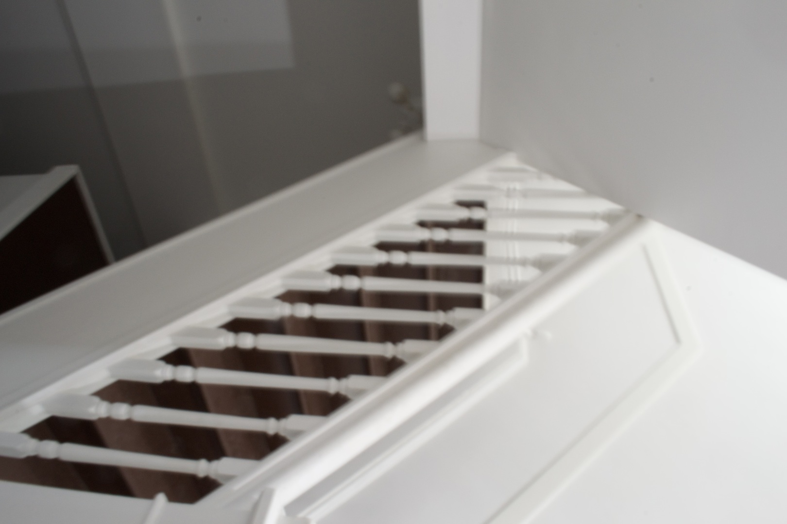 Interior staircase with dark wood steps and a white balustrade with turned spindles.