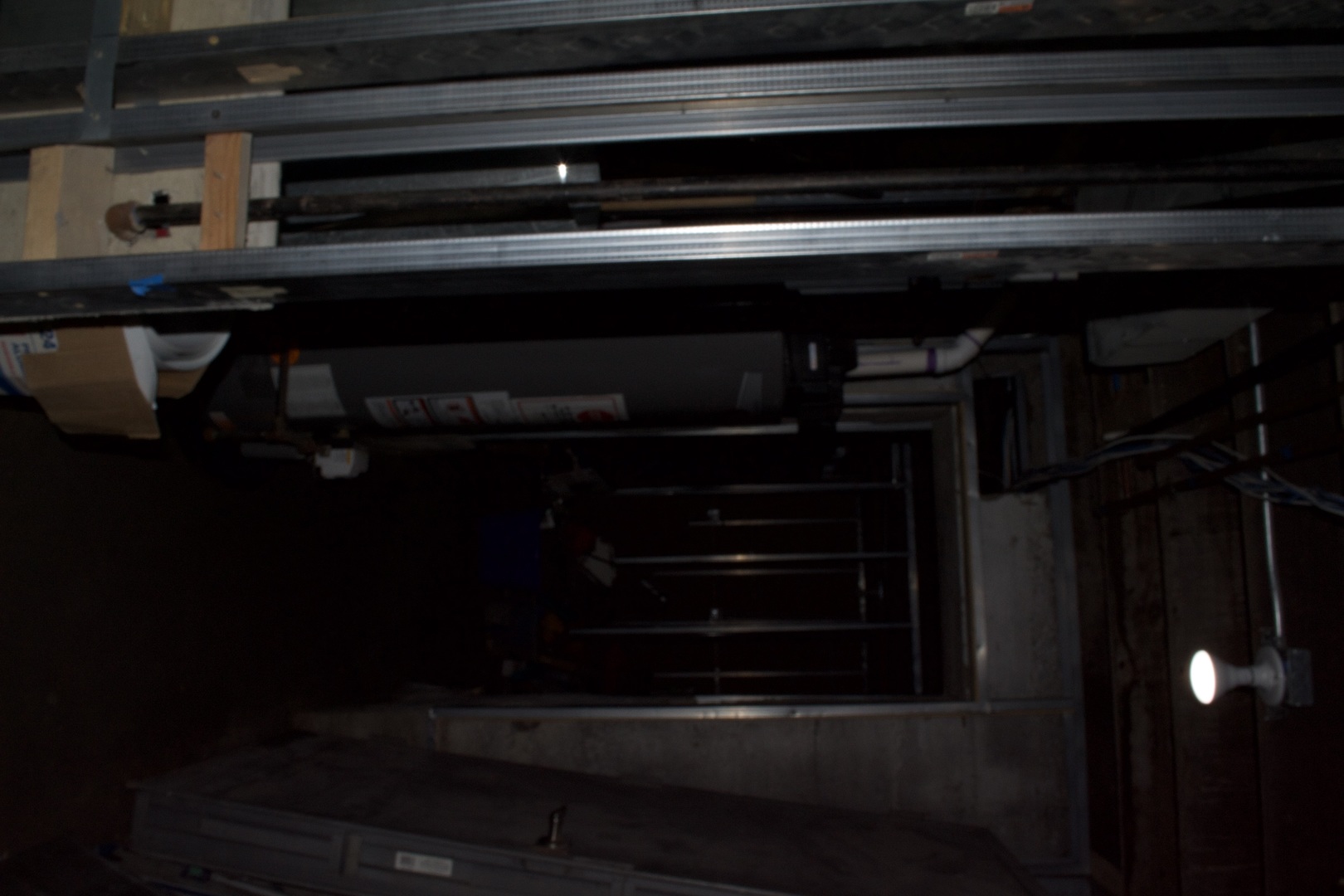 Unfinished garage with overhead metal tracks and exposed framing.