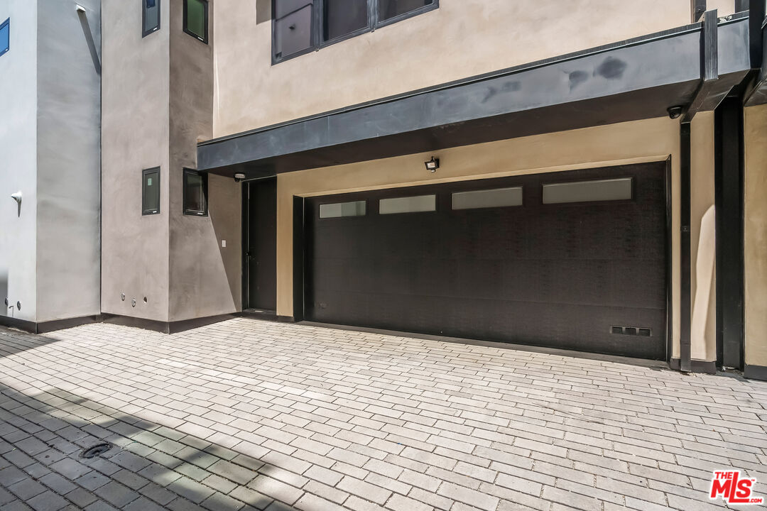 Home exterior with a wide dark garage door and paved driveway.