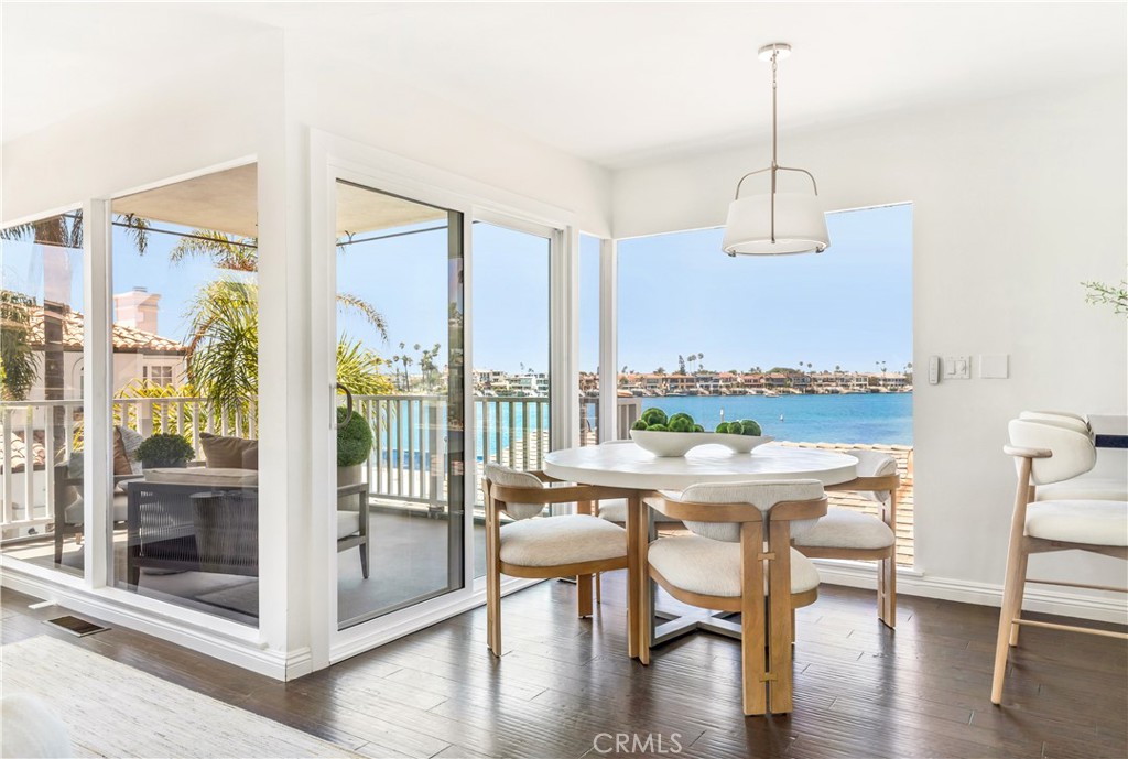 Dining area with sliding glass doors and a balcony overlooking the water.