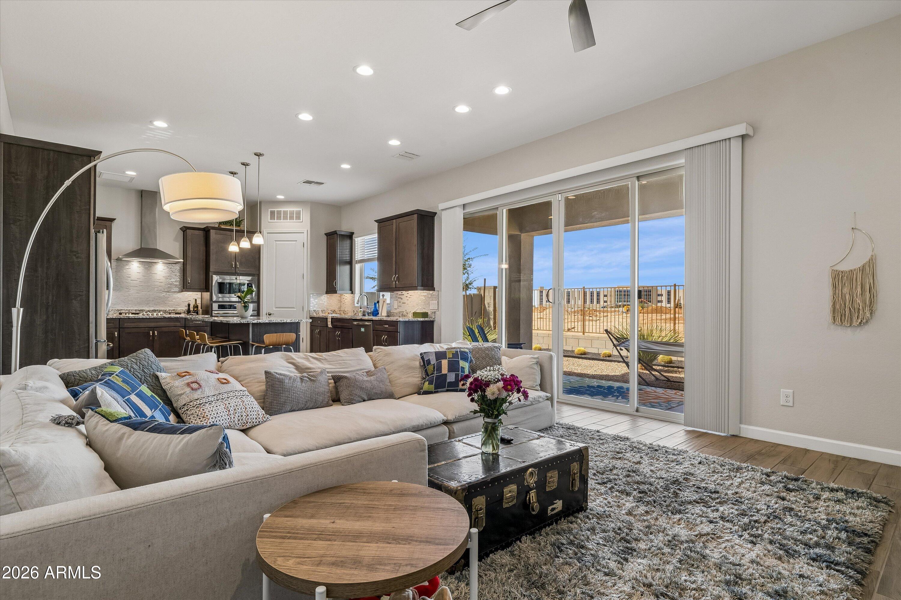 Living room with a cream sectional, open kitchen, and sliding glass doors to the patio.