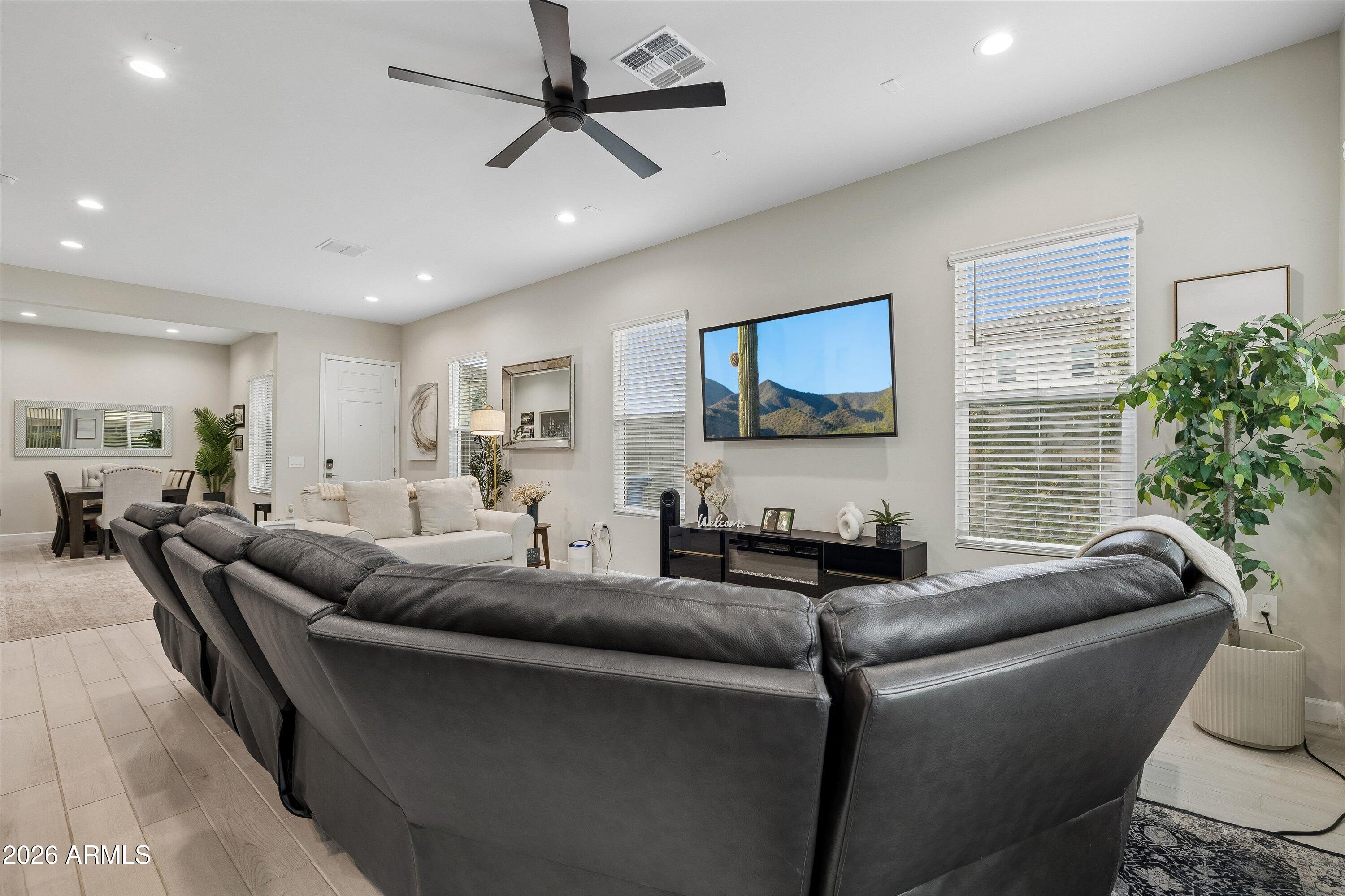 Furnished living room with a charcoal sectional, white sofa, and wall-mounted television.