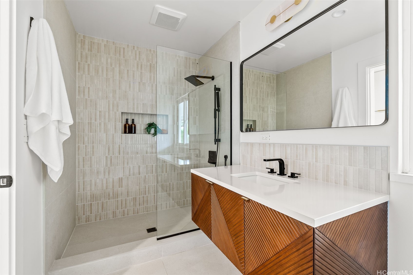 Modern bathroom with a glass walk-in shower and wood-front vanity.