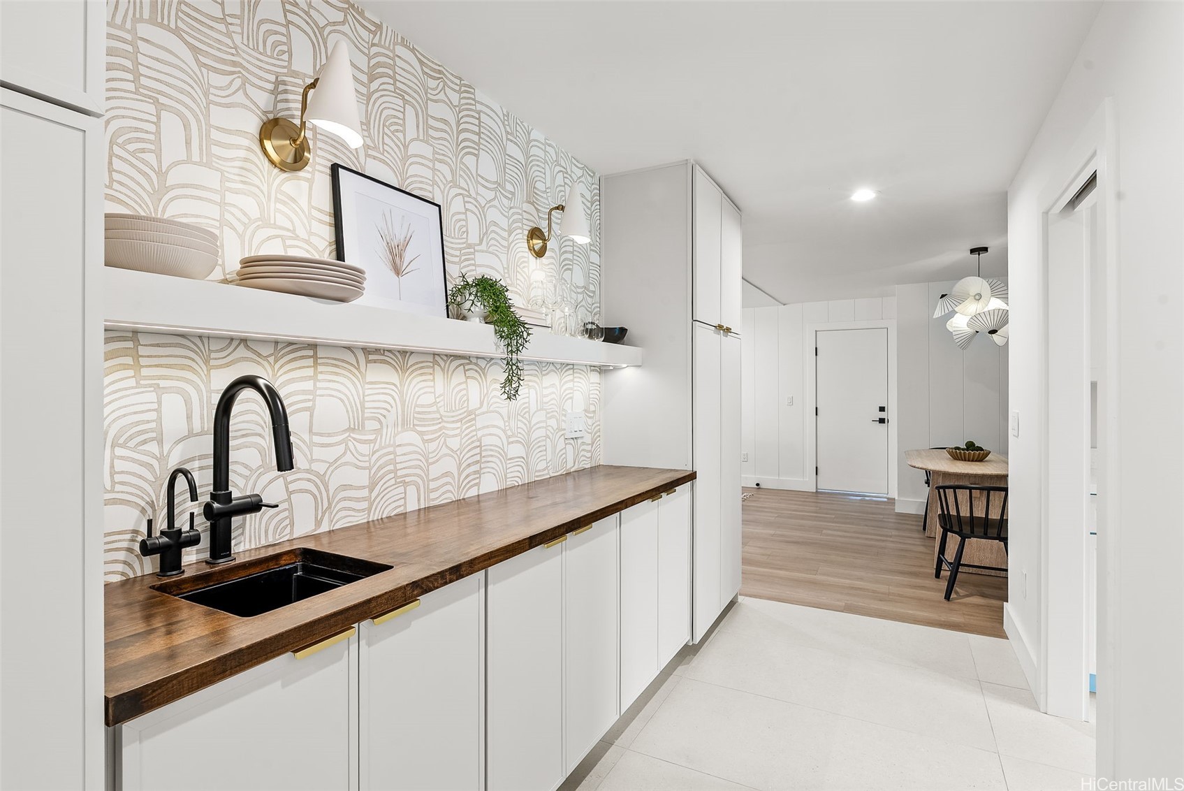 Modern kitchen with patterned wallpaper, a dark wood counter, and a black sink.