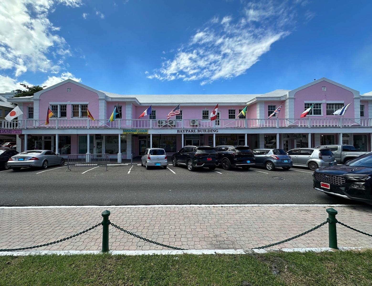 Bayparl Building, a pink two-story commercial property with flags along its balcony and cars parked outside.