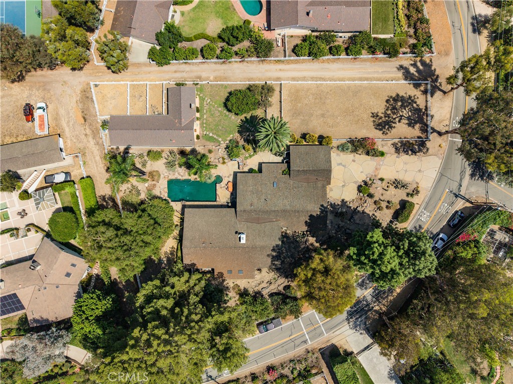 Aerial view of a home with a swimming pool and large fenced lot.