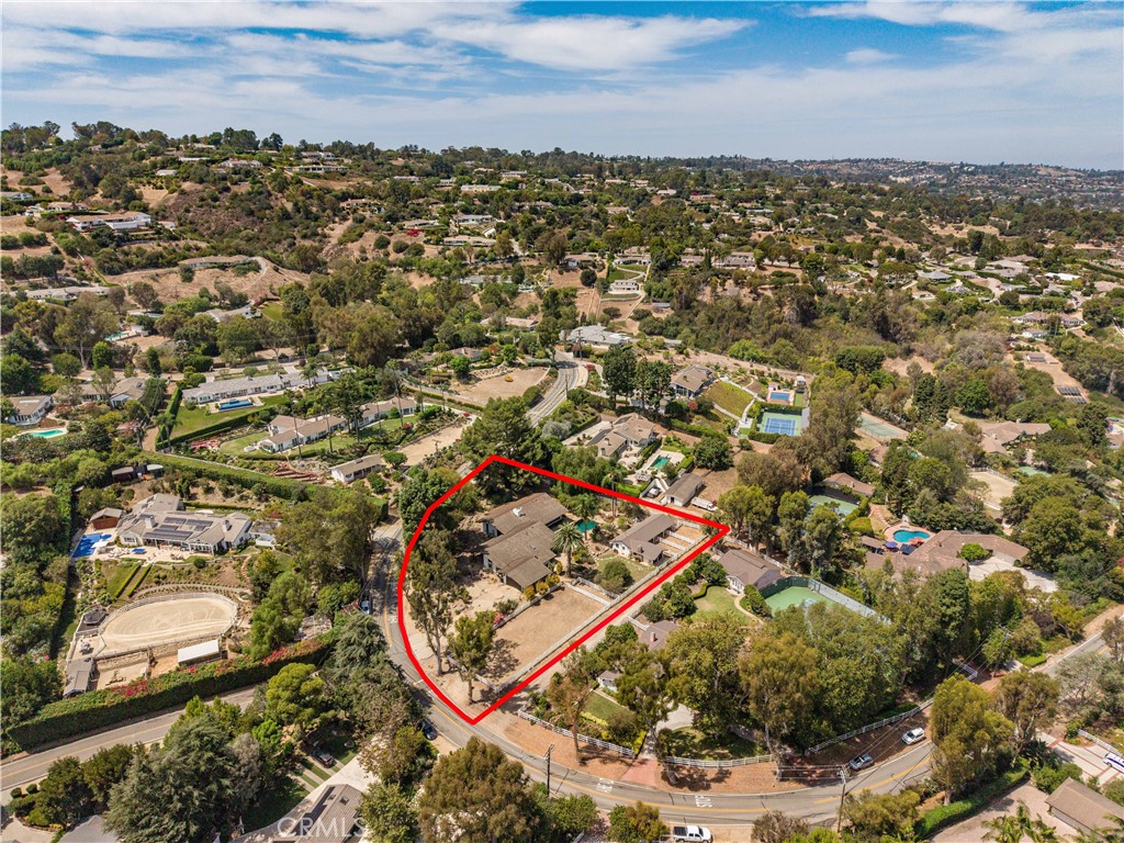 Aerial view of a large hillside home and grounds outlined in red.