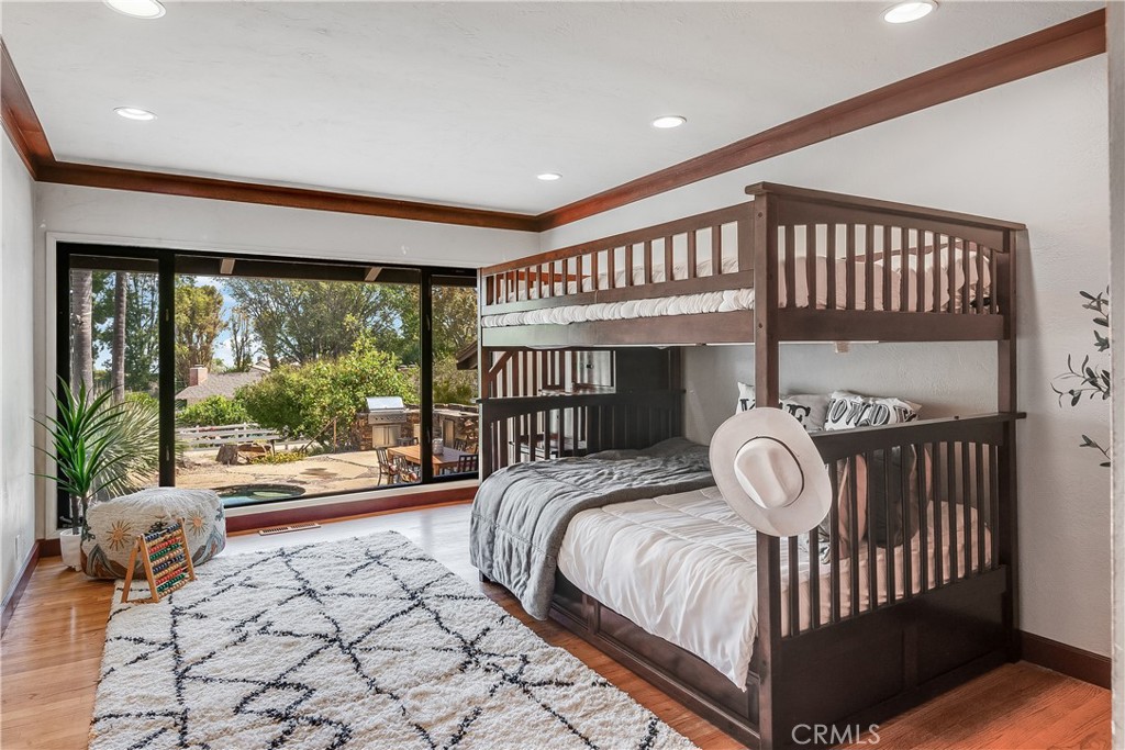 Bedroom with a dark wood bunk bed beside a wide sliding glass door to the patio.