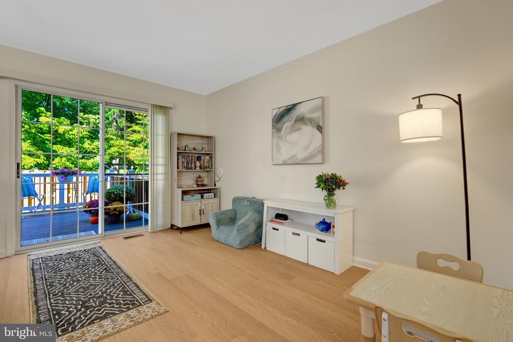 Living room with sliding glass doors opening to a tree-lined deck.