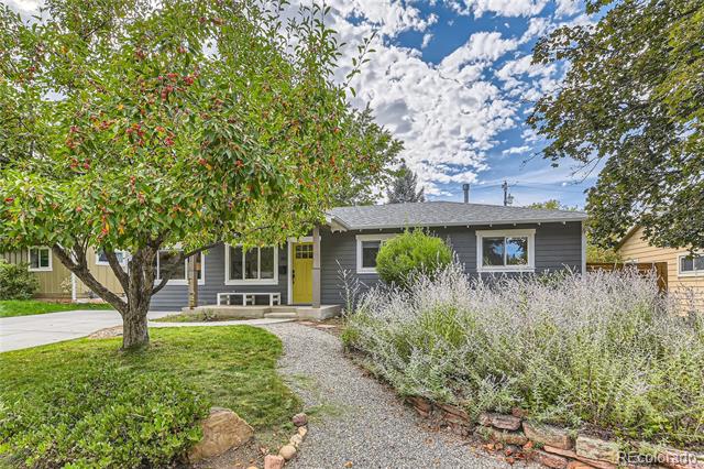 Single-story gray house with a bright yellow front door and landscaped yard.