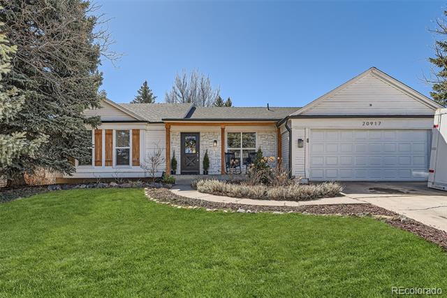 Single-story home with stone accents, a two-car garage, and a broad green front lawn.