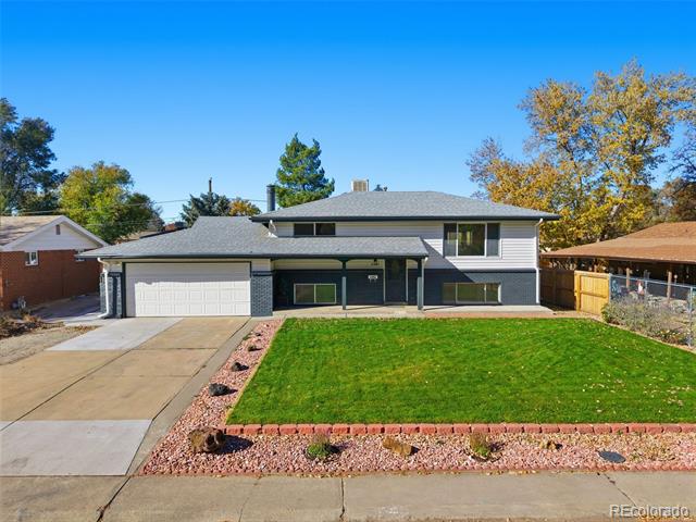 Two-story house with an attached garage, wide driveway, and green front lawn.