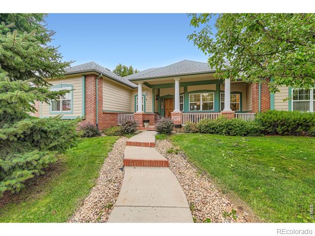 Single-story home with brick accents, a covered porch, and a curved walkway through the landscaped front yard.