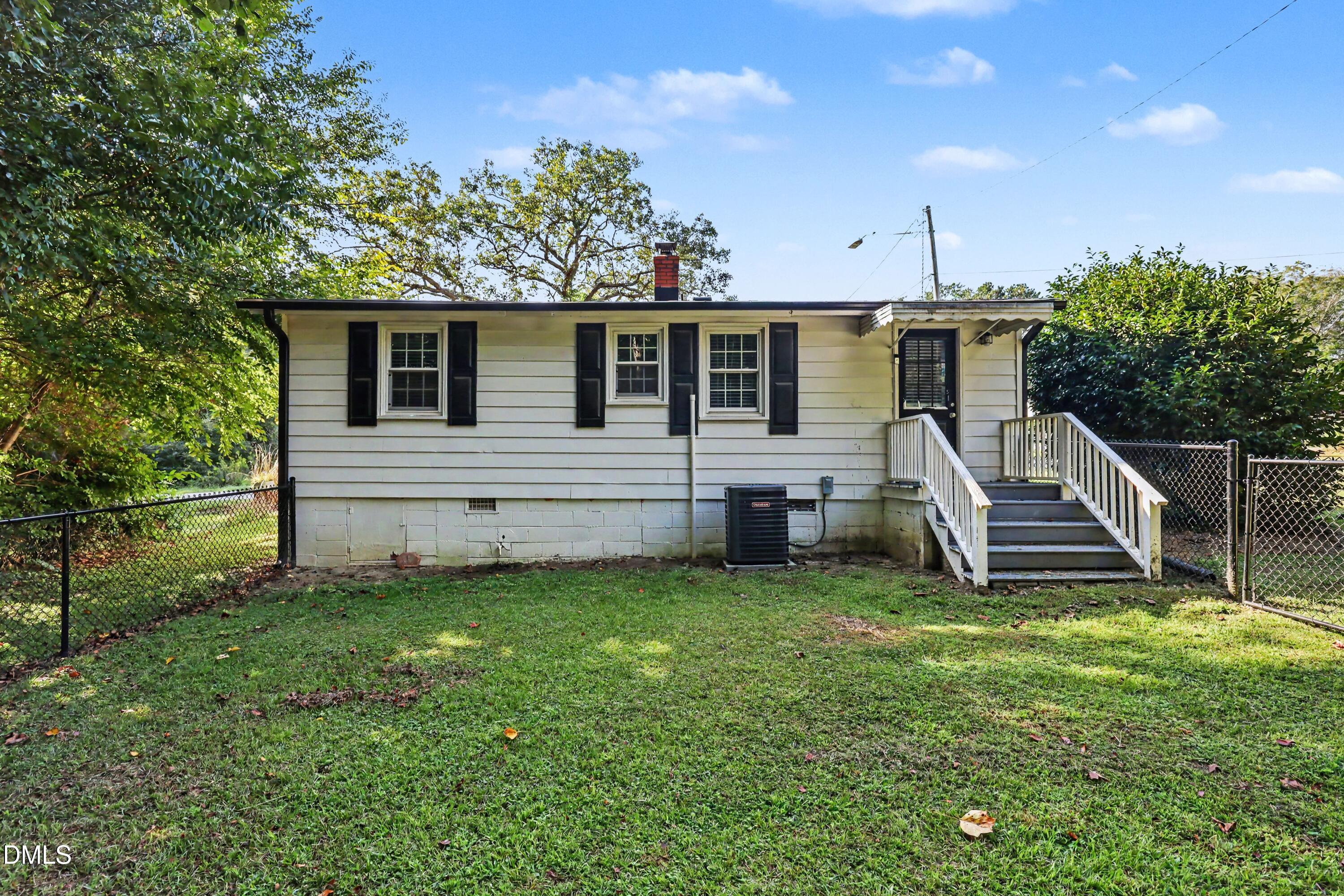 Rear exterior of 106 W Allen Street with raised entry stairs and a fenced grassy yard.