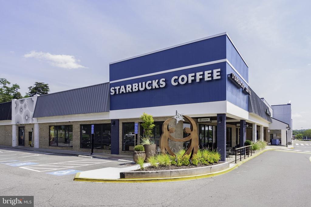 Starbucks Coffee storefront with prominent blue signage and landscaped entrance.