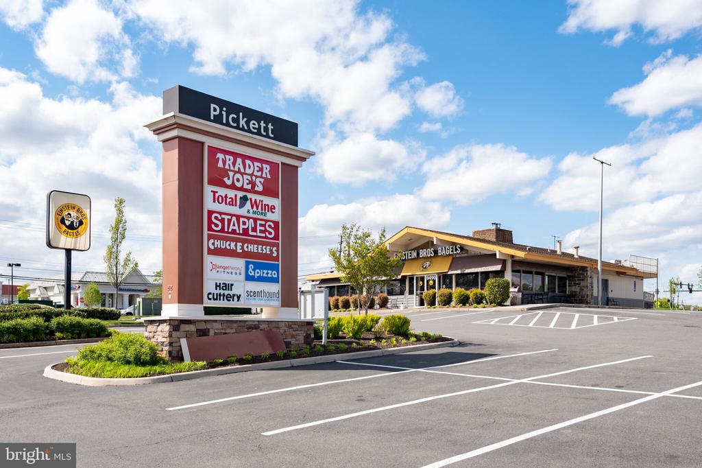 Shopping center with a tall Pickett tenant sign and Einstein Bros. Bagels beside the parking lot.