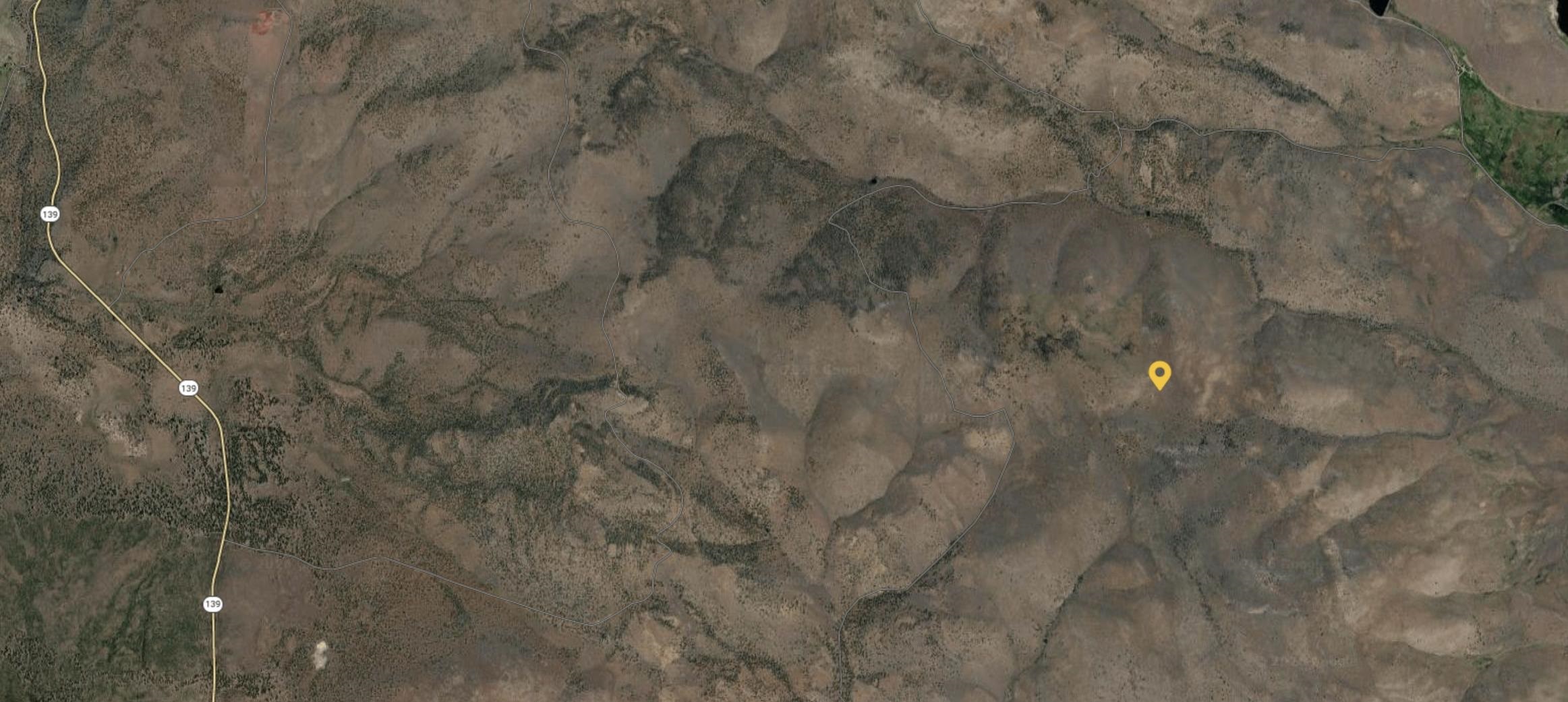 Aerial view of dry, sparsely vegetated terrain near Highway 139, marked with a yellow location pin.