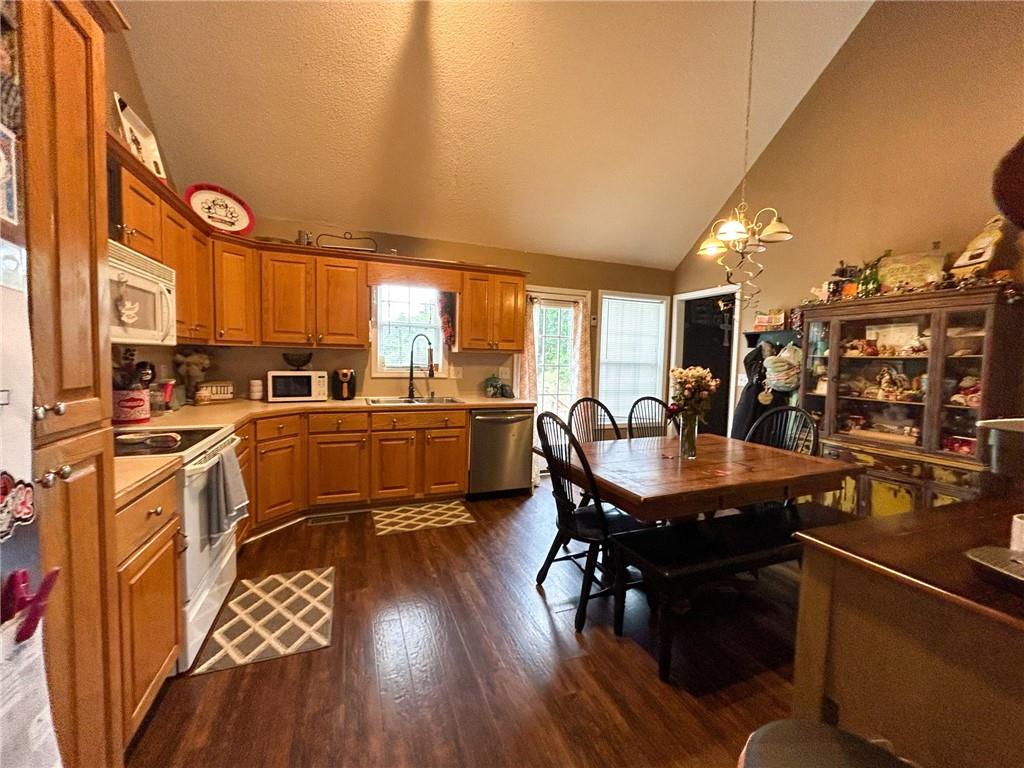 Kitchen and dining area with wood cabinets, stainless steel appliances, and a large wooden table.