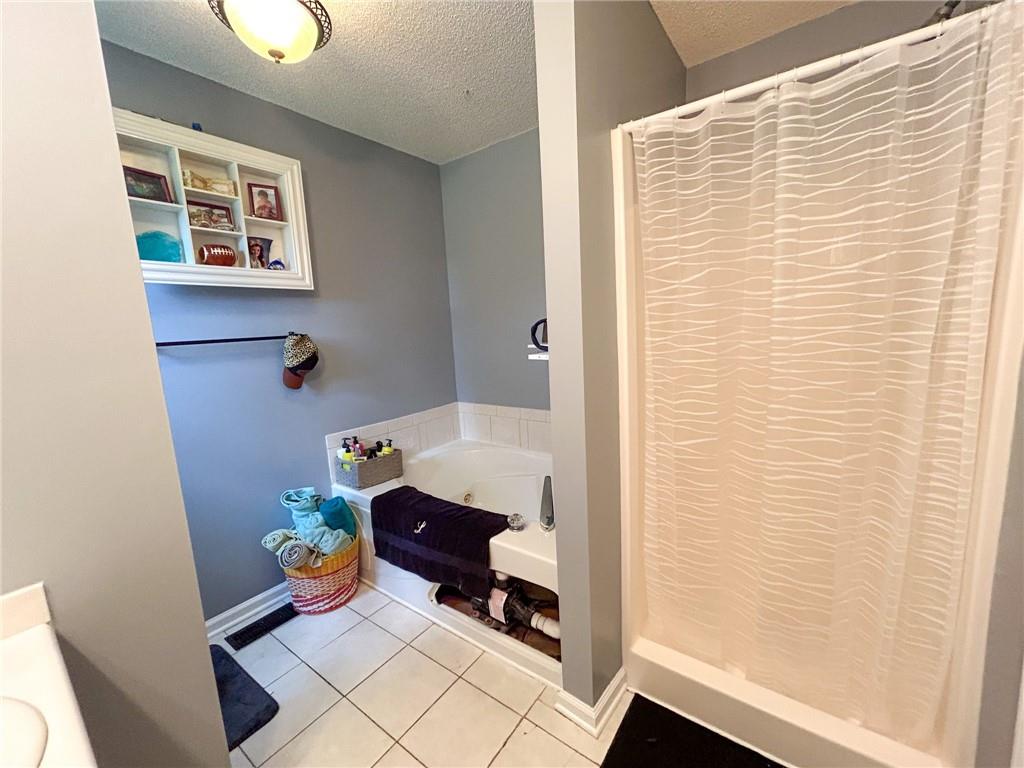Bathroom with a patterned shower curtain, gray walls, and a built-in display shelf.