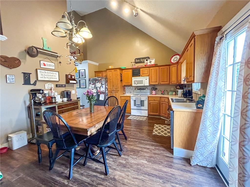 Kitchen and dining area with wood cabinets, a large table, and a vaulted ceiling.