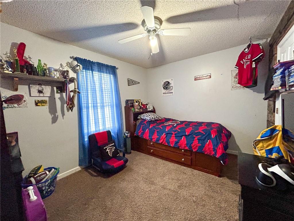 Bedroom with Falcons bedding, a wooden bed, blue curtains, and sports memorabilia.