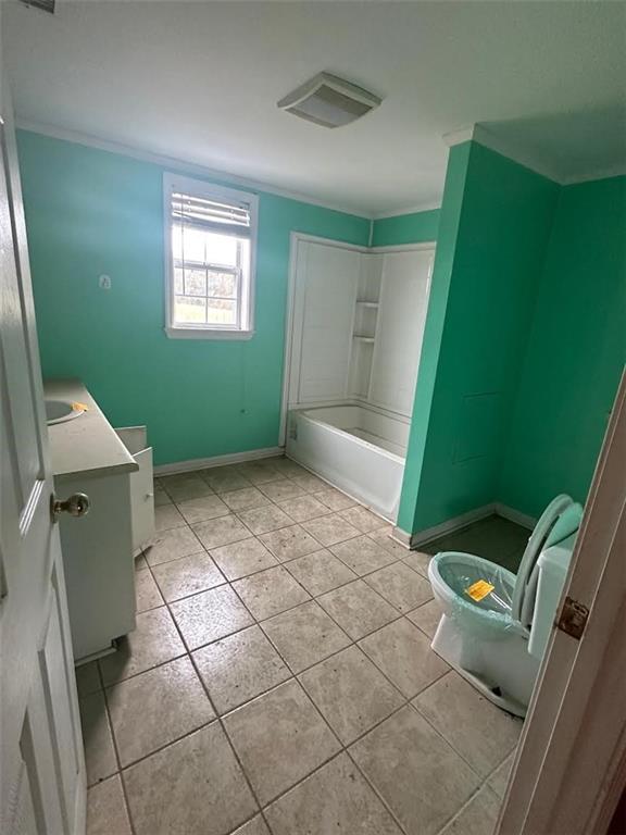 Bathroom with green walls, a white tub and built-in shelves, and large square tile flooring.