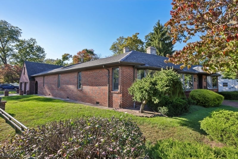 Red brick ranch-style house with a dark hipped roof and landscaped yard.